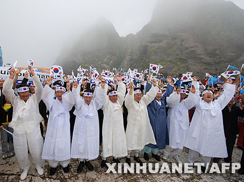 7月14日，大批韓國人在獨島（日本稱“竹島”）手舉國旗抗議。韓國外交通商部發(fā)言人文太暎當日發(fā)表聲明，強烈抗議日本在當天公布的中學(xué)教科書指導(dǎo)手冊中將獨島（日本稱“竹島”）表述為日本領(lǐng)土，并要求日本立即對有關(guān)內(nèi)容進行修正。韓國外交通商部將采取召回韓國駐日本大使和召見日本駐韓國大使這兩項外交措施，就此問題向日本政府表示強烈抗議。 新華社/法新 