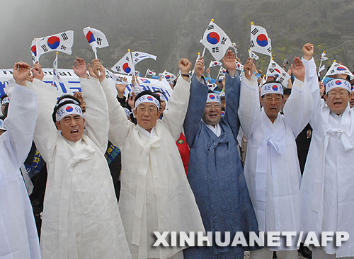 7月14日，大批韓國人在獨(dú)島（日本稱“竹島”）手舉國旗抗議。韓國外交通商部發(fā)言人文太暎當(dāng)日發(fā)表聲明，強(qiáng)烈抗議日本在當(dāng)天公布的中學(xué)教科書指導(dǎo)手冊中將獨(dú)島（日本稱“竹島”）表述為日本領(lǐng)土，并要求日本立即對有關(guān)內(nèi)容進(jìn)行修正。韓國外交通商部將采取召回韓國駐日本大使和召見日本駐韓國大使這兩項(xiàng)外交措施，就此問題向日本政府表示強(qiáng)烈抗議。 新華社/法新 