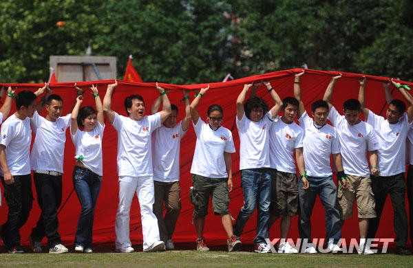  5月11日，成龍等和北川師生共擎巨幅國旗。