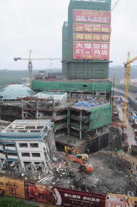5月21日，工程機械在拆除綿陽紫荊民族中學校舍，旁邊則是建設中的萬達廣場。