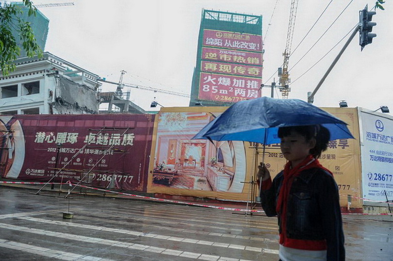 5月21日，一名小學(xué)生從拆遷現(xiàn)場附近街道走過。新華社記者 李橋橋 攝  