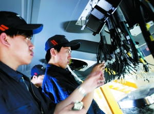 中國北車長春CRH380B生產(chǎn)車間　車廂底部，工人們正安裝線纜。動車制造過程實行嚴格的質(zhì)量管理措施，每個工序、環(huán)節(jié)、零件都是實名制。（圖片來源：新京報）