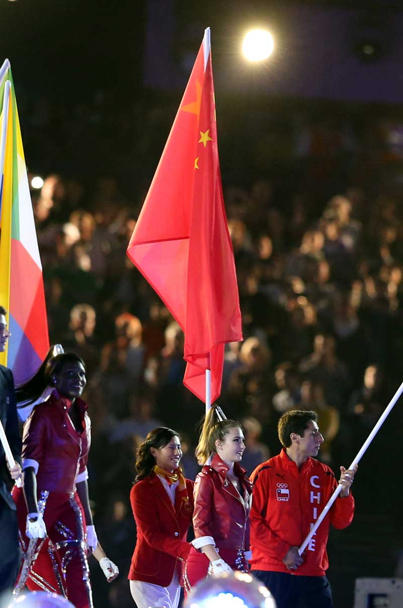 這是中國代表團(tuán)旗手、奧運(yùn)會女子激光雷迪爾級冠軍徐莉佳（右三）在閉幕式上高舉五星紅旗入場。 攝影： 新華社記者  凡軍