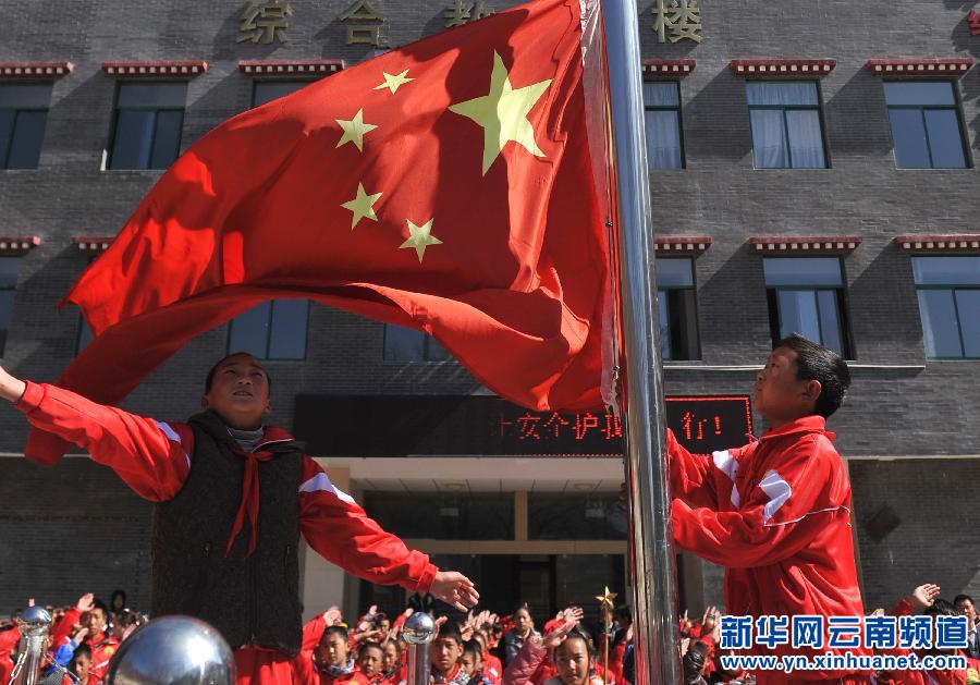 3月17日，云南省迪慶藏族自治州德欽縣第一小學(xué)學(xué)生在教學(xué)樓前參加升旗儀式。新華社 藺以光 攝