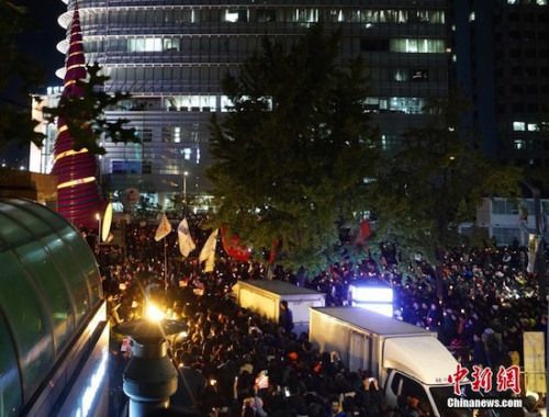  兩萬名韓國民眾及民間團(tuán)體人士在首爾市中心舉行燭光集會，譴責(zé)“親信干政事件”給韓國社會帶來的不良影響，要求總統(tǒng)樸槿惠對此事負(fù)責(zé)。圖為集會現(xiàn)場。<a target='_blank'  data-cke-saved- ><p  align=