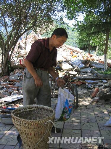 7月5日，北川縣城的一位居民在縣城內(nèi)尋找自己的物品。當(dāng)日，記者經(jīng)特許進(jìn)入地震重災(zāi)區(qū)北川縣城采訪，用相機(jī)記錄下北川縣城的現(xiàn)狀。 